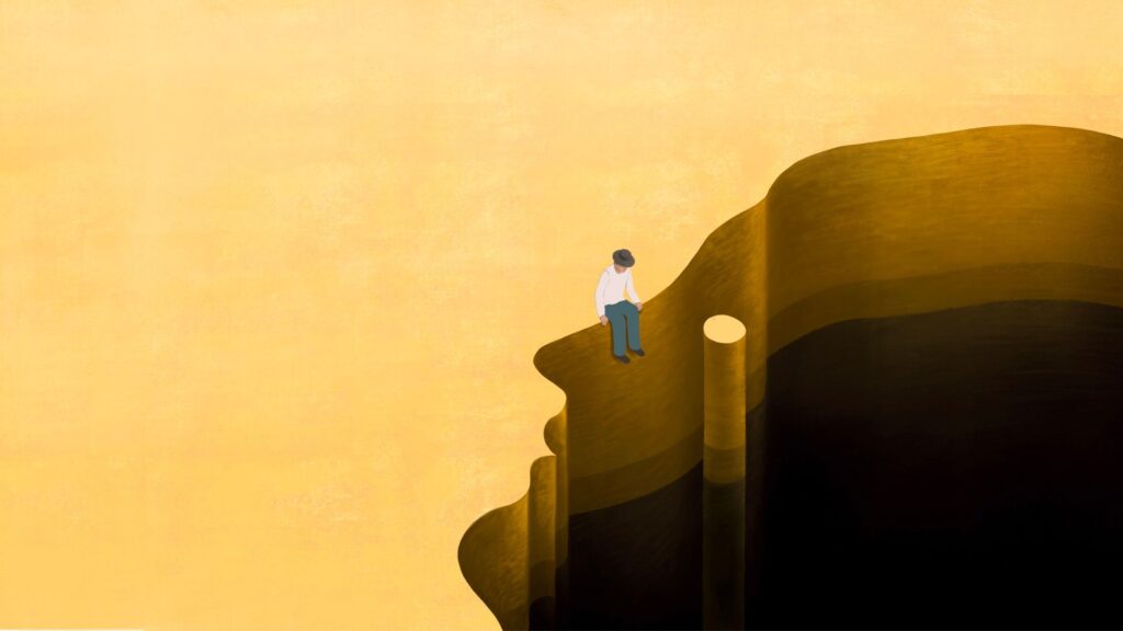 An illustration of a man sitting at the edge of a canyon. The outline of the edge resembles a human face.